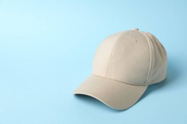 Açık mavi arka planda bej beyzbol şapkası, metin için boşluk
