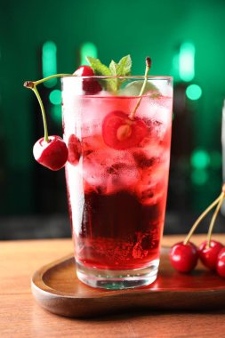 Buzlu vişneli soda, böğürtlen ve nane şekerli yeşil arka planda bulanık, yakın plan.