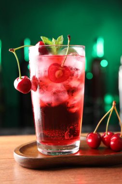 Buzlu vişneli soda, böğürtlen ve nane şekerli yeşil arka planda bulanık, yakın plan.