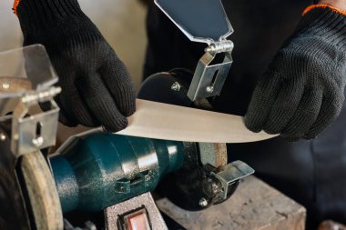 Bıçak keskinleştiren adam içeride, yakın plan.