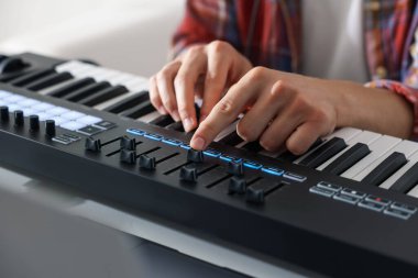 İçerideki masada MIDI klavyesiyle çalışan adam, yakın plan.