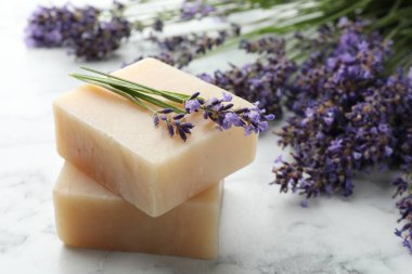 Sabun çubukları ve lavanta çiçekleri beyaz mermer masada, yakın plan.
