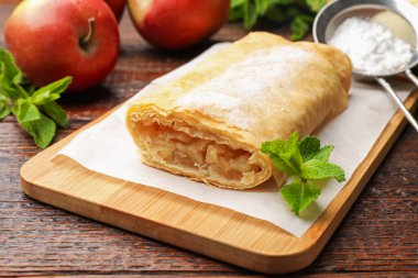 Lezzetli elmalı turta, pudra şekeri, nane ve ahşap masada meyveler, yakın plan.