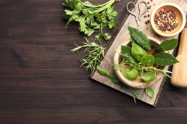 Tahta masada farklı taze otlar ve biberli havan topu. Metin için boşluk