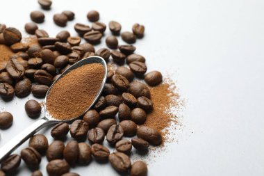 Hazır kahve tozu ve beyaz arka planda fasulye ile kaşık, yakın plan. Metin için boşluk
