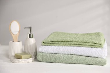 Taze havlu ve kozmetik ürünler beyaz ahşap masada.