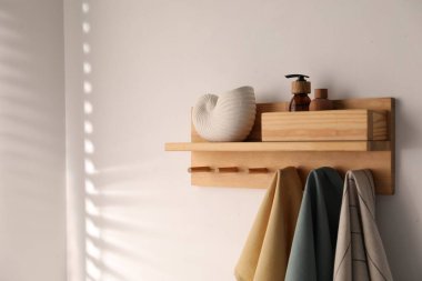 Beyaz arka planda kozmetik ürünleri ve havluları olan raflar. Metin için boşluk