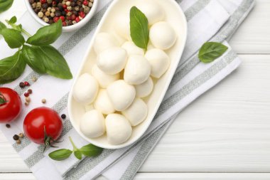 Lezzetli mozzarella peyniri, domates, fesleğen ve baharatlar beyaz ahşap masa, düz yatak. Metin için boşluk