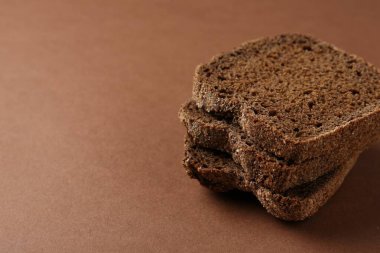 Kahverengi arka planda taze çavdar ekmeği parçaları, yakın plan. Metin için boşluk