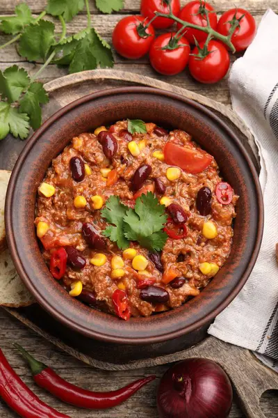 Lezzetli biberli makarna kasede ve ahşap masada malzemeler var.