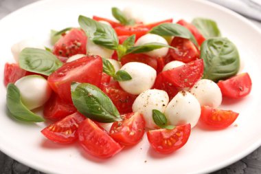 Mozarella, domates, fesleğen ve baharatlı Caprese salatası.