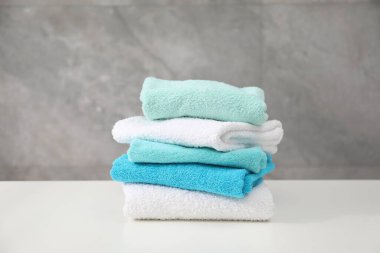 Beyaz masanın üzerinde renkli havlular yığını