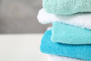 Beyaz masadaki renkli havlular yığını, yakın plan. Metin için boşluk