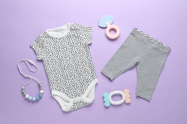 Menekşe arka planda bebek kıyafetleri ve aksesuarlar, düz yatış
