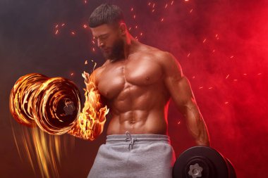 Vücut geliştirici koyu arkaplanda yanan halterlerle egzersiz yapıyor.