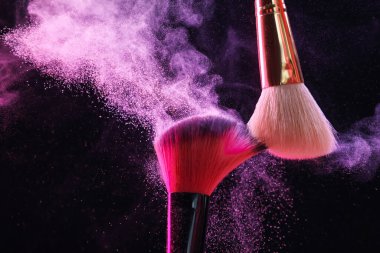 Renkli göz gölgeli makyaj fırçaları siyah arka planda neon ışıkları, yakın plan