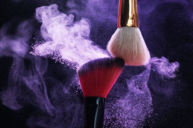 Siyah arka planda mor göz farlı makyaj fırçaları, yakın plan