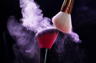 Siyah arka planda mor göz farlı makyaj fırçaları, yakın plan