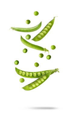 Beyaz arkaplana düşen yeşil bezelyeler ve kabuklar