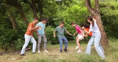 Takım oluşturma. Bir grup mutlu insan dışarıda örümcek ağı oynuyor.