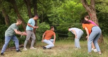 Takım oluşturma. Bir grup mutlu insan dışarıda örümcek ağı oynuyor.