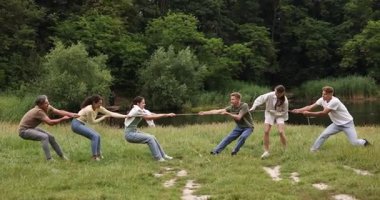 Takım oluşturma. Dışarıda halatla çekme oyunu oynayan bir grup mutlu insan.