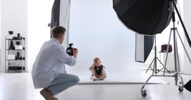 Profesyonel fotoğraf stüdyosunda modelle çalışan bir fotoğrafçı.