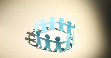 Işık arkaplanına gölge düşüren insan kağıt figürleri, yakın plan