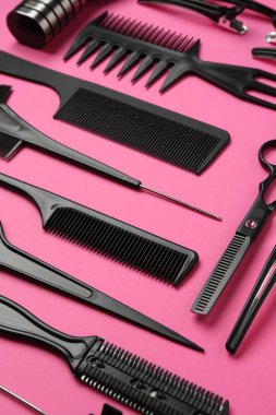Pembe arka planda farklı kuaför araçları, yakın plan