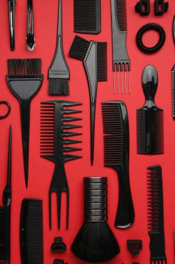 Kırmızı arka planda farklı kuaför aletleri, düz yatıyordu