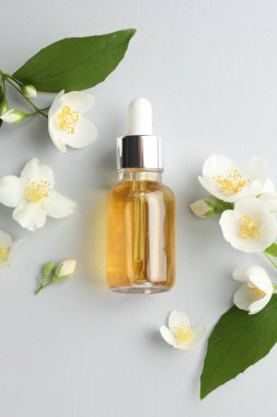 Kozmetik ürünleri ve yasemin çiçekleri arka planda, düz yatıyordu