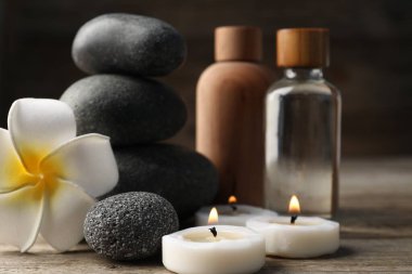 Kozmetik ürünleri ve spa taşlarıyla ahşap masaya yakın plan kompozisyon.