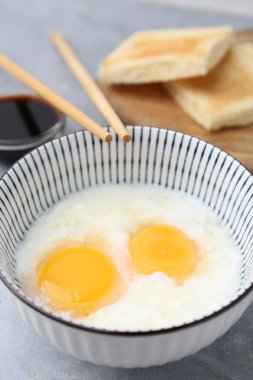 Kavanozda yarı haşlanmış yumurta, soya sosu, ekmek ve çubuklarla geleneksel Asya kahvaltısı, yakın plan.