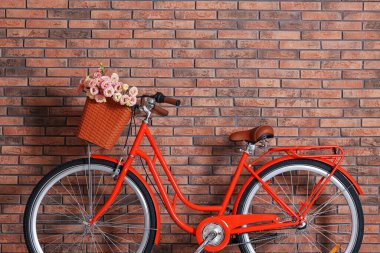 Evin içinde tuğla duvarın yanında bir sepet güzel çiçekli bisiklet. Metin için boşluk