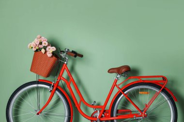 Açık yeşil duvarın yanında bir sepet güzel çiçekli bisiklet. Metin için boşluk