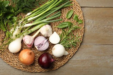 Farklı taze otlar, soğan ve sarımsak. Tahta masa, düz yatak. Metin için boşluk