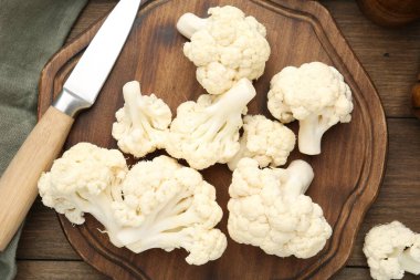 Taze taze karnabahar çiçekleri ve tahta masanın üzerinde bıçak, düz yatıyordu.