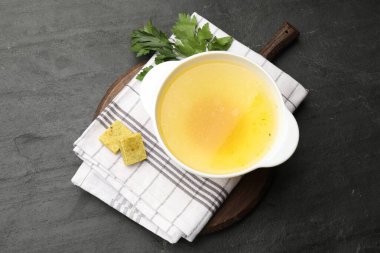 Aromatik bulyon küpleri, et suyu ve maydanoz siyah masada, üst manzara