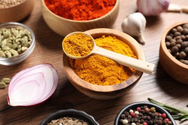 Ahşap masada farklı aromatik baharatlar, yakın plan.