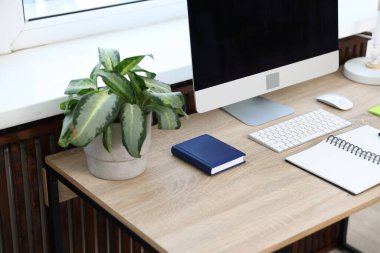 Modern bilgisayarlı, ahşap masadaki şık iş yeri, yakın çekim.