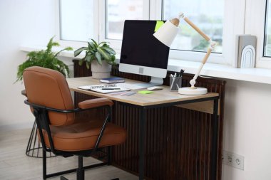 Ofisteki ahşap masada modern bilgisayar ve kırtasiye malzemeleri. Rahat bir iş yeri