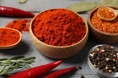 Gri ahşap masada farklı aromatik baharatlar, yakın plan.