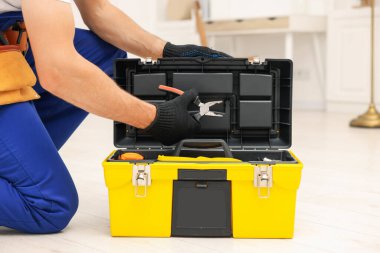 Alet kutusu ve pensesi içeride olan profesyonel bir tamirci, yakın plan.