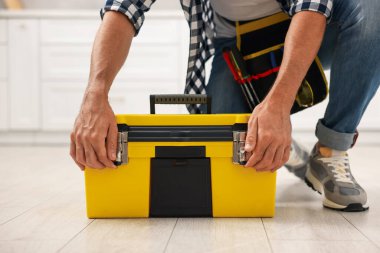 Kapalı mekanda alet çantası olan profesyonel bir tamirci.