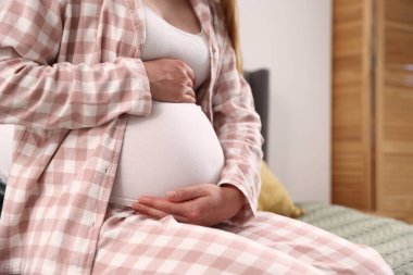 Evdeki yatakta güzel hamile bir kadın, yakın plan.