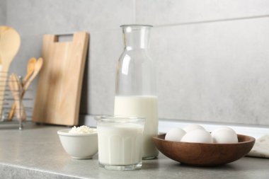 Mutfaktaki gri desenli masada farklı süt ürünleri ve yumurtalar.