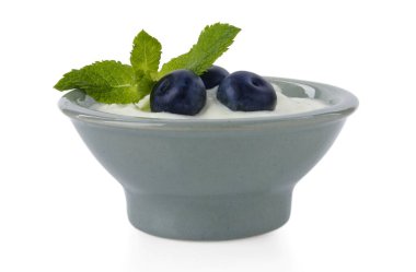 Lezzetli yoğurt yaban mersinli ve nane şekerli beyaz tencereye izole edilmiş.