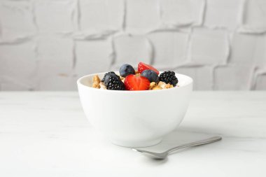 Tahıllı yoğurt ve beyaz mermer masada böğürtlen, yakın plan.