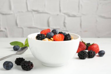 Tahıllı yoğurt ve beyaz masada böğürtlen, yakın plan.