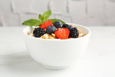 Tahıllı yoğurt ve beyaz mermer masada böğürtlen, yakın plan.